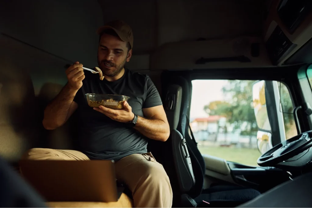 Truck driver eating food in truck