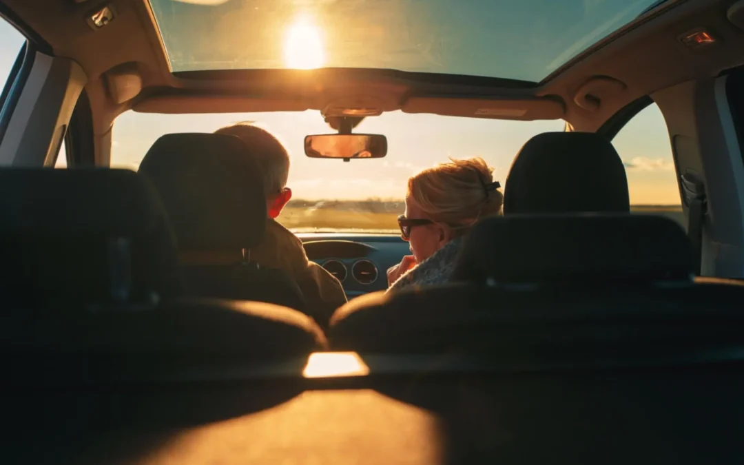 A couple in a car with sunset ahead