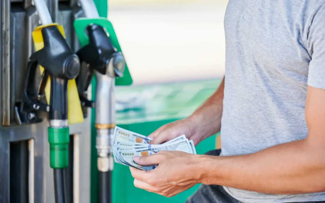 Man holding cash outside at gas pump